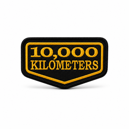 10 Thousand Kilometres embroidered patch in black and yellow with premium stitching and precision border on white background