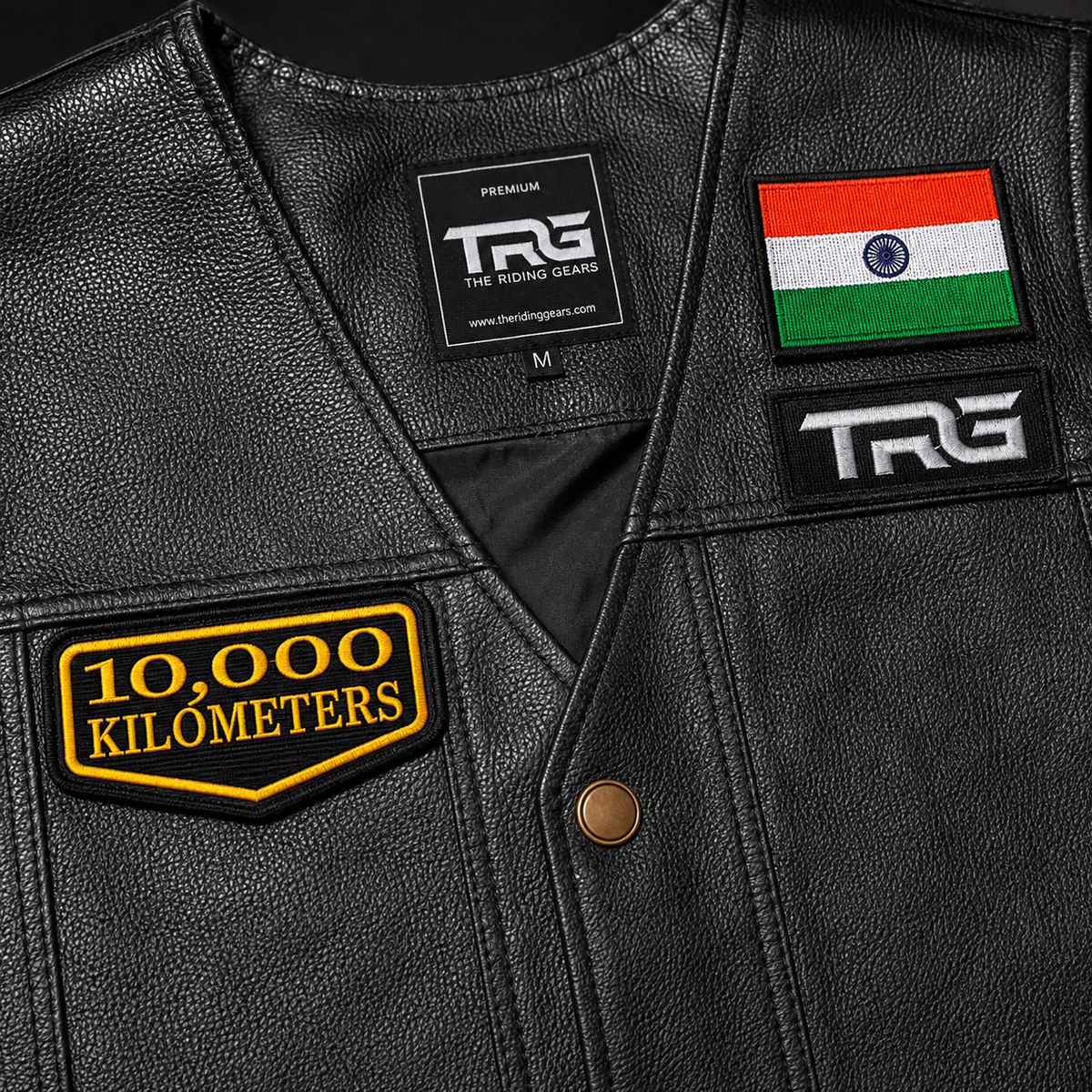Close-up of 10 Thousand Kilometres embroidered patch on black leather vest showing premium yellow embroidery and precision border
