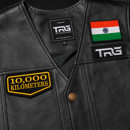 Close-up of 10 Thousand Kilometres embroidered patch on black leather vest showing premium yellow embroidery and precision border