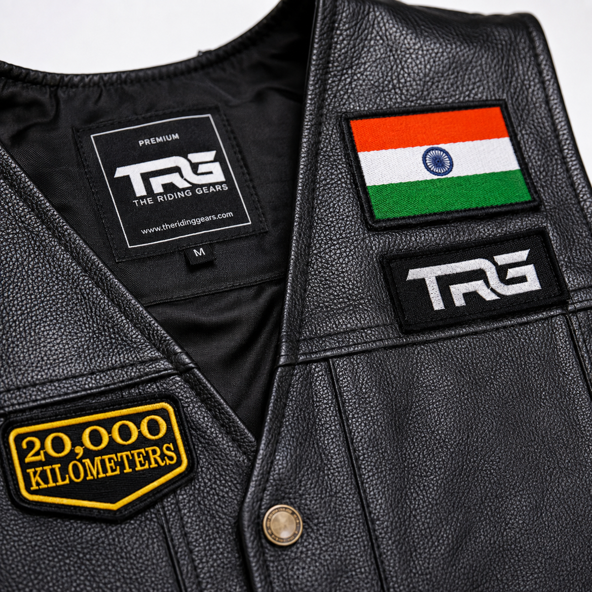 Close-up of 20 Thousand Kilometres embroidered patch on black leather biker vest showing premium yellow stitching