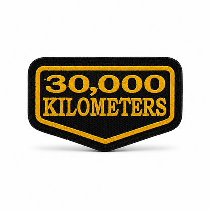 30 Thousand Kilometres embroidered patch in black and yellow with premium embroidery and precision stitched border on white background