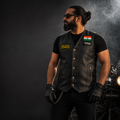 Motorcycle rider wearing 80 Thousand Kilometres embroidered patch on black leather vest beside motorcycle