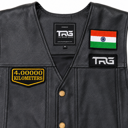 Close-up of 4 Lakh Kilometres embroidered patch on black leather vest showing detailed yellow embroidery and border