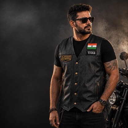 Motorcycle rider wearing 4 Lakh Kilometres embroidered patch on black leather vest beside motorcycle