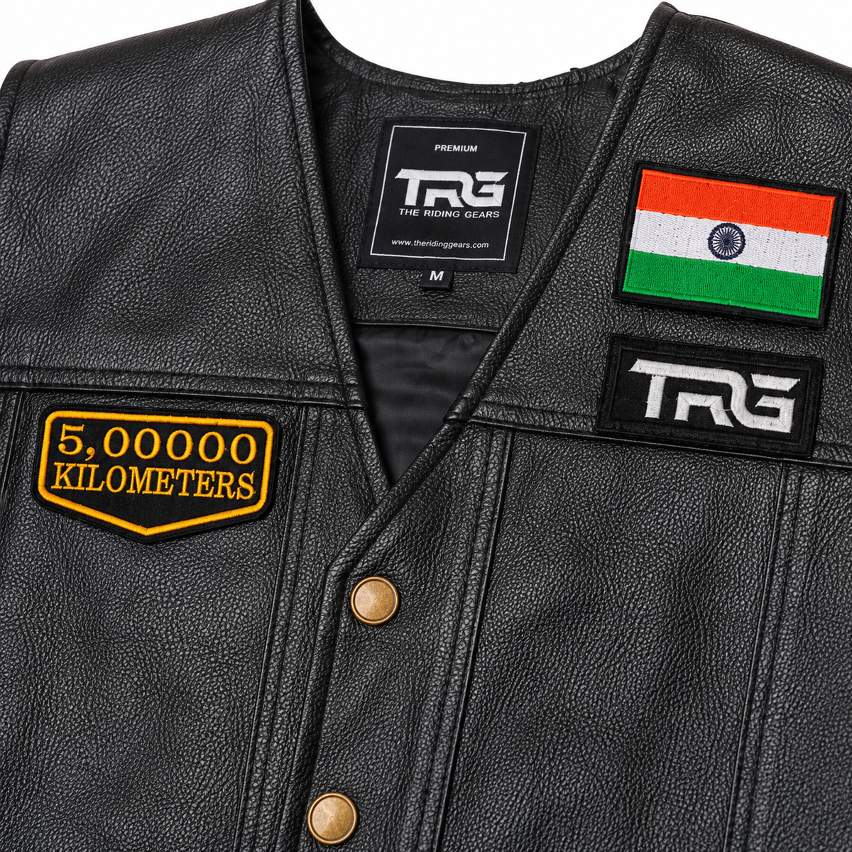 Close-up of 5 Lakh Kilometres embroidered patch on black leather vest showing yellow embroidery, black twill fabric and detailed stitched border