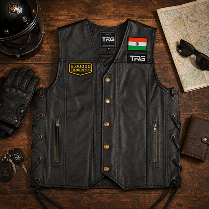 5 Lakh Kilometres embroidered patch displayed on black leather motorcycle vest with helmet, gloves, map and riding accessories