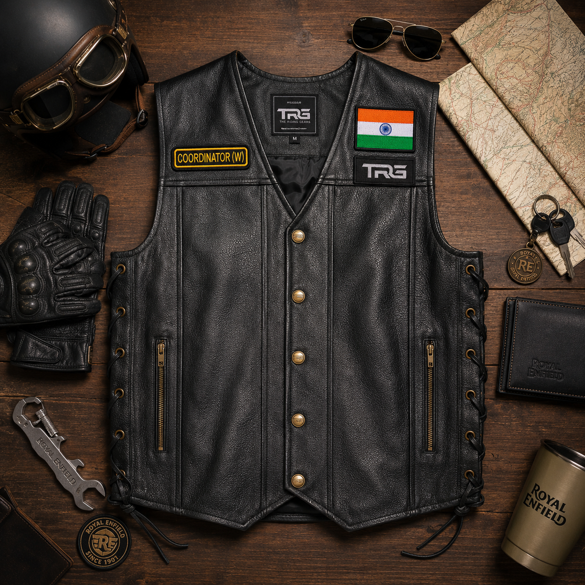 Coordinator (W) front designation patch on a black leather biker vest in a premium motorcycle flat lay.