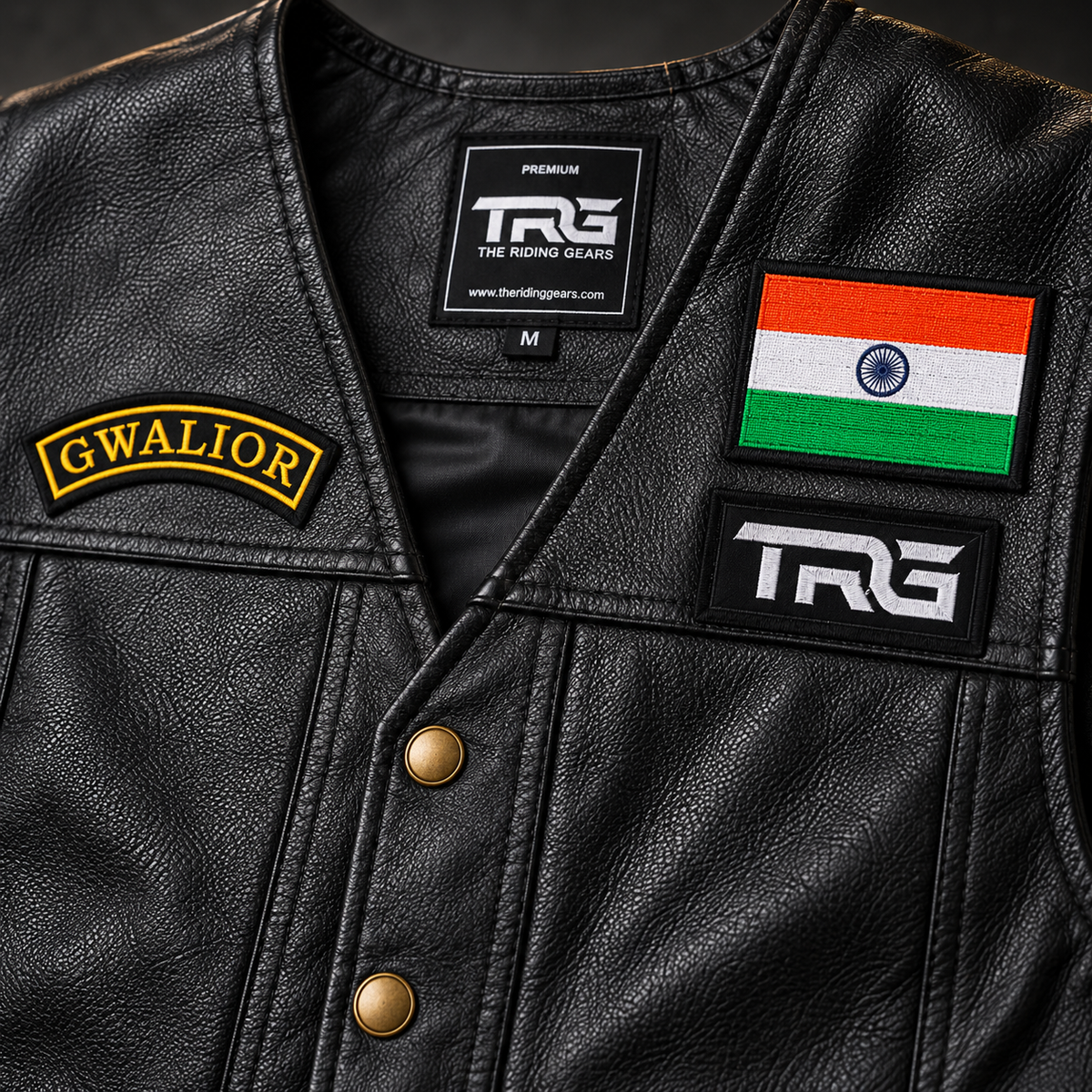 Close-up of Gwalior yellow and black embroidered chest patch on a textured leather riding vest.