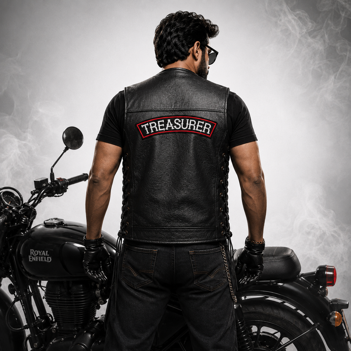 Treasurer back designation patch worn on black leather biker vest by motorcycle rider in studio setting.